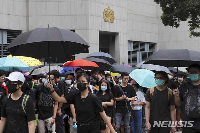 【홍콩=AP/뉴시스】26일 홍콩 주재 영국영사관 앞에서 시위대가 마스크를 쓰고 검은 우산을 들고 침묵시위를 벌였다. 최근 대규모 시위를 주도했던 시민단체인 '민간인권전선'은 이번 시위를 주도하고, 중국을 제외한 G20 19개 회원국 영사관을 돌면서 관련 내용이 담긴 청원서를 전달했다. 2019.06.26 