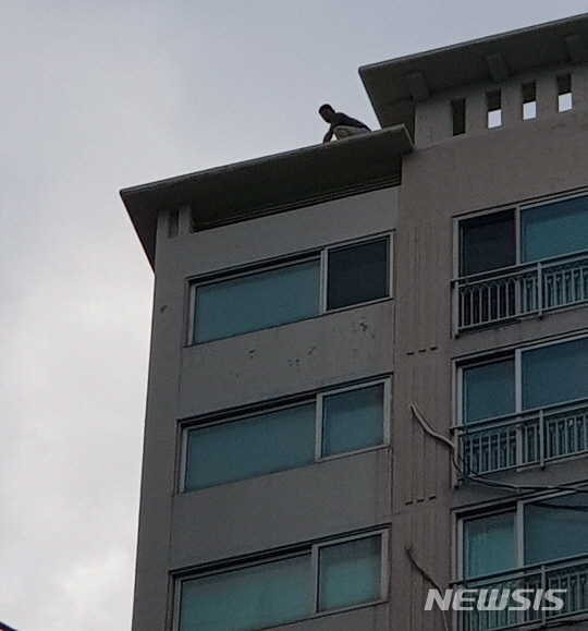 경남 거제시 옥포1동 한 아파트 20층 옥상에서 경찰과 대치중인 박모(45)씨 모습. (사진=거제경찰서 제공)