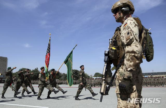 【카불=AP/뉴시스】10일(현지시간) 아프가니스탄 카불의 아프간 군사학교 에서 3개월 간의 교육훈련을 마친 병사들의 수료식이 열린 가운데 나토군 병사가 경계 근무를 서고 있다. 2019.07.10.