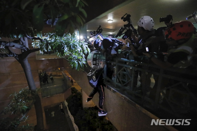 【홍콩=AP/뉴시스】13일(현지시간) 홍콩 시위대 가운데 한 명이 난간에 매달려있다. 이 시위대는 홍콩 경찰에 의해 무사히 구조됐다. 2019.07.14