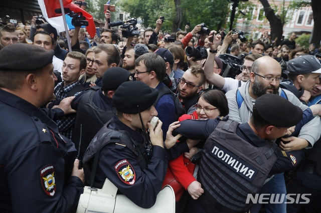 【모스크바=AP/뉴시스】 14일(현지시간) 러시아 모스크바의 선거관리위원회 건물 앞에서 시위대와 경찰들이 몸싸움을 하고 있다. AP통신 등에 따르면 선관위가 야당 정치인들의 피선거권을 박탈하려 한다는 소식에 시위대 2000여명은 선관위 앞에 모여 "이 곳의 주인은 우리" "푸틴(러시아 대통령)은 도둑"을 외치며 항의했다. 2019.07.15.