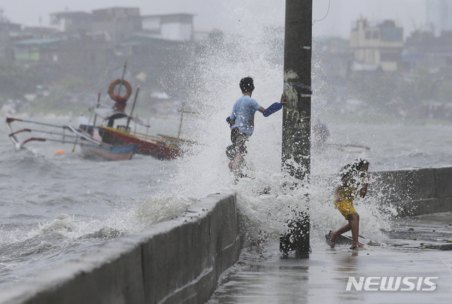 【마닐라=AP/뉴시스】17일(현지시간) 필리핀 마닐라만에서 어린이들이 태풍 '다나스'의 영향으로 높아진 파도를 맞으며 놀고 있다.  필리핀 당국은 제5호 태풍 '다나스'가 16일 오후 필리핀 인근 해상에서 발생해 시속 23km의 속도로 서쪽으로 이동하면서 폭우를 동반해 마닐라 메트로폴리탄 지역의 학교들에 휴교령이 내려졌다고 밝혔다. 2019.07.17.