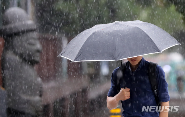 【제주=뉴시스】우장호 기자 = 제주도청 인근 거리에 7월 18일 우산을 쓴 시민이 출근길 발걸음을 재촉하고 있다. (뉴시스DB) woo1223@newsis.com