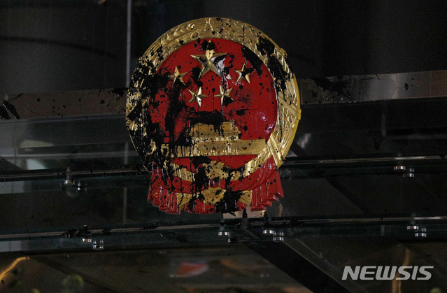 The National Emblem of the People&#039;s Republic of China is covered in black paint thrown by protesters outside the Chinese Liaison Office in Hong Kong, Sunday, July 21, 2019. Protesters in Hong Kong pressed on Sunday past the designated end point for a march in which tens of thousands repeated demands for direct elections in the Chinese territory and an independent investigation into police tactics used in previous demonstrations. (AP Photo/Bobby Yip)