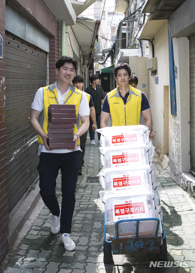 【서울=뉴시스】동서식품 임직원들이 7월29일 서울 종로구 창신동 쪽방촌에 지원할 폭염구호키트를 운반하고 있다. 