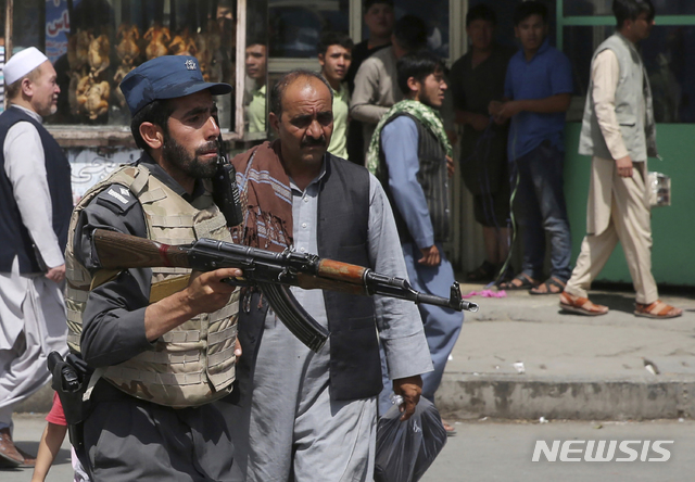 【카불=AP/뉴시스】 8월 7일 아프가니스탄의 수도 카불에서 자폭 테러로 14명의 사망자가 발생한 뒤 현장 부근의 경찰본부를 총을 들고 지키는 아프간 경찰.  