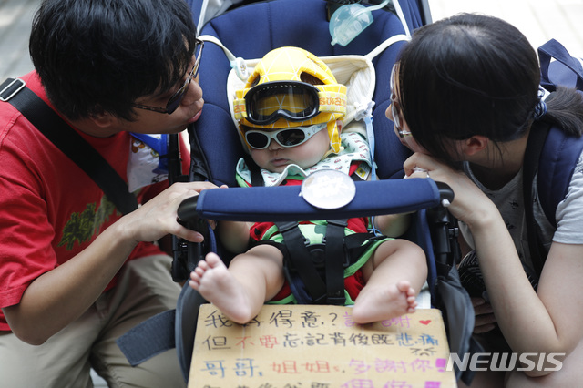  【홍콩=AP/뉴시스】10일 홍콩 도심에서 범죄인 인도법안(송환법) 반대 시위가 열린 가운데 한 부부가 유모차에 탄 아이를 바라보고 있다. 이날 시위대는 완차이에서 애드미럴티까지 2시간 동안 가두 행진을 벌였다. 2019.08.10 