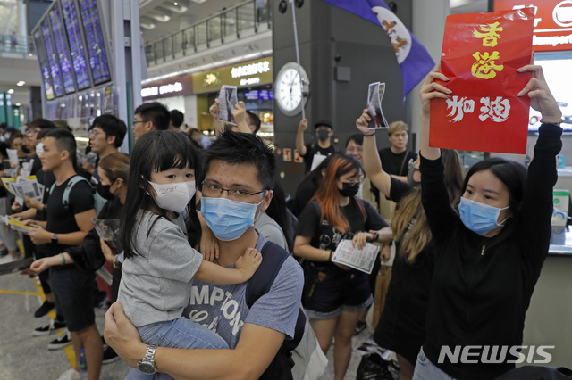 【홍콩=AP/뉴시스】10일 홍콩 국제공항에서 마스크를 쓴 시위대들이 서있는 모습. 범죄인 인도법안(송환법) 반대 집회가 두달 넘게 이어지는 가운데 시위대는 세계인들에게 시위의 정당성을 알리기 위해 9일 공항 시위를 시작했다. 2019.08.11. 