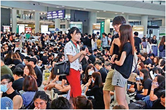 【서울=뉴시스】지난 10일 홍콩 친중 성향 언론 다궁바오가 보도한 사진으로, 홍콩 국제공항에서 캐세이퍼시픽 유니폼을 입은 여직원이 홍콩 시위대와 대화를 나누고 있다. <사진출처: 다궁바오> 2019.08.12 