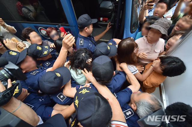 【제주=뉴시스】우장호 기자 = 12일 오전 제주지법에서 전 남편을 잔혹하게 살해한 뒤 시신을 훼손·유기한 혐의를 받는 고유정(36)의 첫 공판이 열린 가운데 시민들이 호송차에 오르는 고유정의 머리채를 잡아 당기고 있다. 2019.08.12.  woo1223@newsis.com 