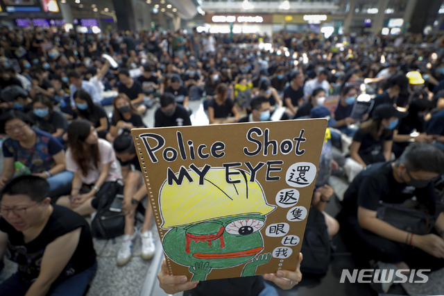 【홍콩=AP/뉴시스】12일(현지시간) 홍콩 국제공항 입국장에서 연좌시위를 벌이는 시위대가 경찰의 고무탄 발사로 한 여성이 실명한 것에 대해 항의하는 시위를 벌이고 있다. 지난 11일 홍콩 경찰이 고글을 착용한 한 여성 시위자에게 고무탄을 쏴 고글을 깨고 들어간 탄환이 여성을 실명시킨 것으로 전해진 바 있다. 2019.08.13.