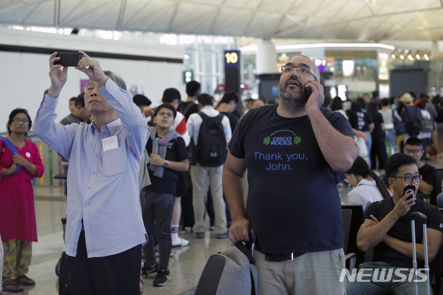 【홍콩=AP/뉴시스】12일(현지시간) 홍콩 국제공항 출국장에서 여행객들이 출국 항공편 운항 정보를 확인하고 있다. 홍콩 국제공항은 이날 성명을 통해 5천여 명의 시위대가 공항에 모여 이로 인해 공항 운영이 “심각하게 방해"됐다며 홍콩발 항공편에 대한 모든 탑승 수속 서비스를 중단했다. 2019.08.12.