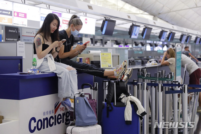 【홍콩=AP/뉴시스】홍콩 시위대의 점거로 항공 운항이 중단된 홍콩 국제공항 출국 수속장에서 12일(현지시간) 여행객들이 스마트폰을 검색하고 있다. 수천 명의 시위대가 공항 입국장에 몰려들어 12일 항공기 운항을 중단했던 홍콩 국제공항은 13일 오전 운항을 재개했다고 밝혔다. 2019.08.13.