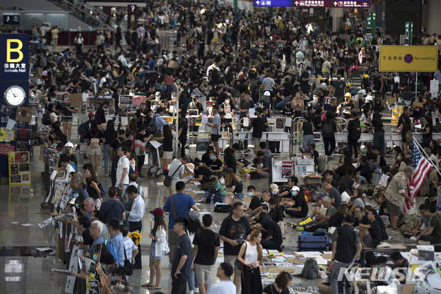 13일 홍콩 시민 시위대가 13일 낮 5일째 국제공항 도착장에서 연좌농성을 벌이고 잇다. 당국은 오후 4시반 이후 항공사 체크인 를 전면 중단했다    AP 