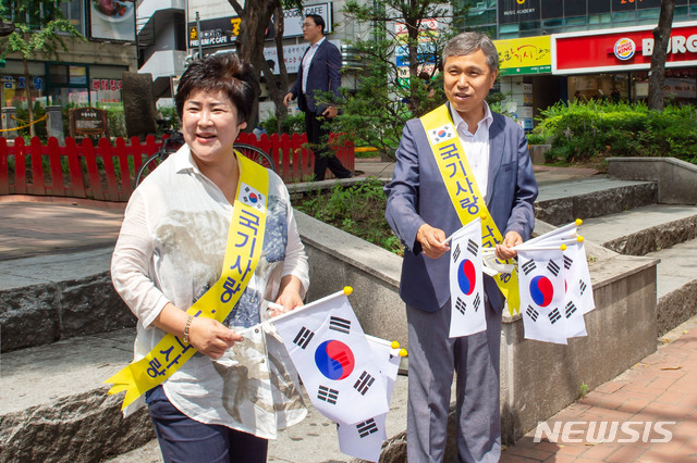  이건한 용인시의회 의장이 14일 시민들에게 태극기를 무료로 나누어 주고 있다. (사진제공=용인시의회)