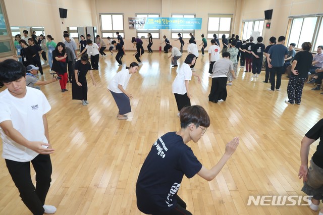 【고성(경남)=뉴시스】신정철 기자=경남 고성군 고성읍에 소재한 고성오광대전수관에는 14일, 불볕더위에도 고성탈놀이를 배우기 위해 전국에서 모여든 350여명의 젊은이들의 열정으로 활활 타오르고 있다. 고성오광대 여름탈놀이 배움터에 올해도 방학을 맞이한 한국예술종합대학생, 이화여대, 한양대, 서울예대, 고려대, 경주대 학생과 고성군내 초등학생들이 고성오광대 전수자 및 이수자들의 지도 아래 오광대 기본과정부터 과장교육, 판소리특강, 오광대 의상 및 소품착용법, 악기연주 등을 배우고 있다. 2019.08.14.(사진=고성군 제공)  photo@newsis.com