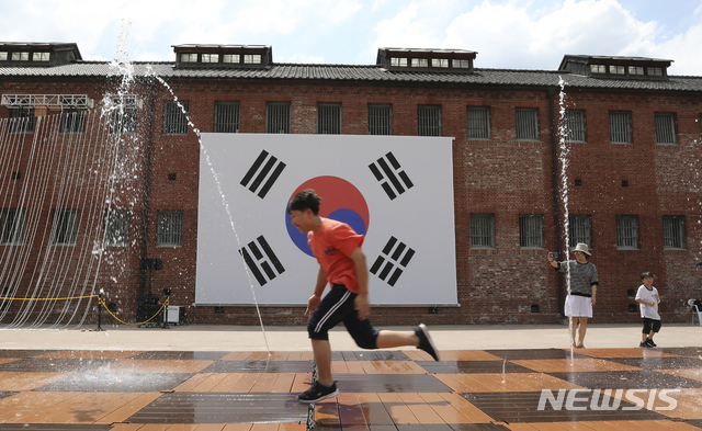 [서울=뉴시스] 최진석 기자 = 서울 서대문구 현저동 서대문형무소역사관에서 학생들이 태극기 앞에서 뛰놀며 더위를 식히고 있다. 2019.08.14.myjs@newsis.com