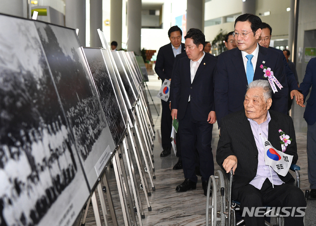 【광주=뉴시스】변재훈 기자 = 노동훈 애국지사와 이용섭 광주시장이 제74주년 광복절을 맞은 15일 오전 광주 서구 광주시청 1층 시민숲에서 열린 '광주 100년 사진으로 만나다' 전시를 관람하고 있다. 2019.08.15. (사진=광주시 제공) photo@newsis.com