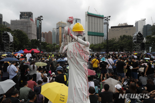 【홍콩=AP/뉴시스】18일 대규모 반정부 시위를 위해 집결한 홍콩 시위대 앞에 안전모를 쓰고 가스 마스크를 착용한 채 수갑이 채워진 민주 여신상이 세워져 있다. 이날 대규모 시위가 예정된 가운데 인근 선전(深圳)에서 중국 무장 공안이 훈련을 벌이며 무력 시위를 했다. 2019.8.18