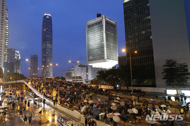 Protesters march in the rain in Hong Kong Sunday, Aug. 18, 2019. Heavy rain fell on tens of thousands of umbrella-toting protesters Sunday as they marched from a packed park and filled a major road in Hong Kong, where mass pro-democracy demonstrations have become a regular weekend activity this summer. (AP Photo/Vincent Thian)