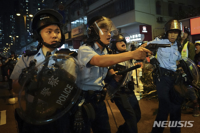 【홍콩=AP/뉴시스】25일 홍콩 도심에서 한 경찰관들이 시위대를 향해 총을 겨누고 있다. 범죄인 인도법(송환법) 반대 12번째 주말 집회가 이날 열린 가운데 시위대로부터 생명의 위협을 느낀 한 경찰관이 경고로 공중에 실탄 사격을 한 것으로 알려졌다. 2019.08.26 