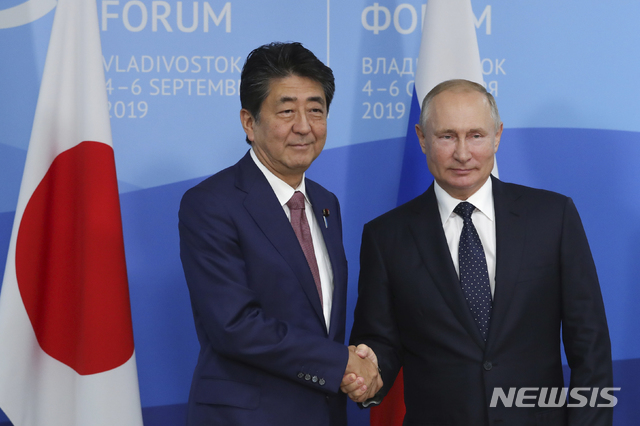 [블라디보스토크=AP/뉴시스]아베 신조 일본 총리(왼쪽)과 블라디미르 푸틴 러시아 대통령이 지난해 9월 5일 러시아 블라디보스토크에서 열린 제5회 극동경제포럼에서 만나 악수하고 있다. 2020.05.07.
