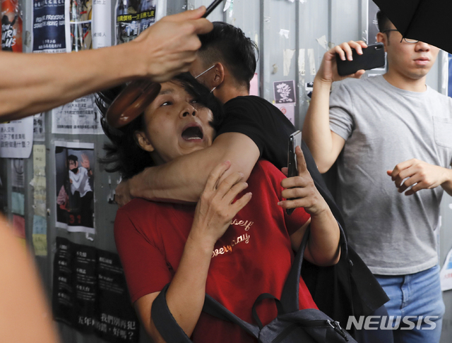 【홍콩=AP/뉴시스】14일 홍콩 카우룽베이 아모이 프라자에서 반중 시위에 참여한 남성(검은옷)이 친중 집회 참여 여성을 공격하고 있다. 이곳에서 친중 반중 시위대간 몸싸움이 벌어졌다. 2019.09.14 