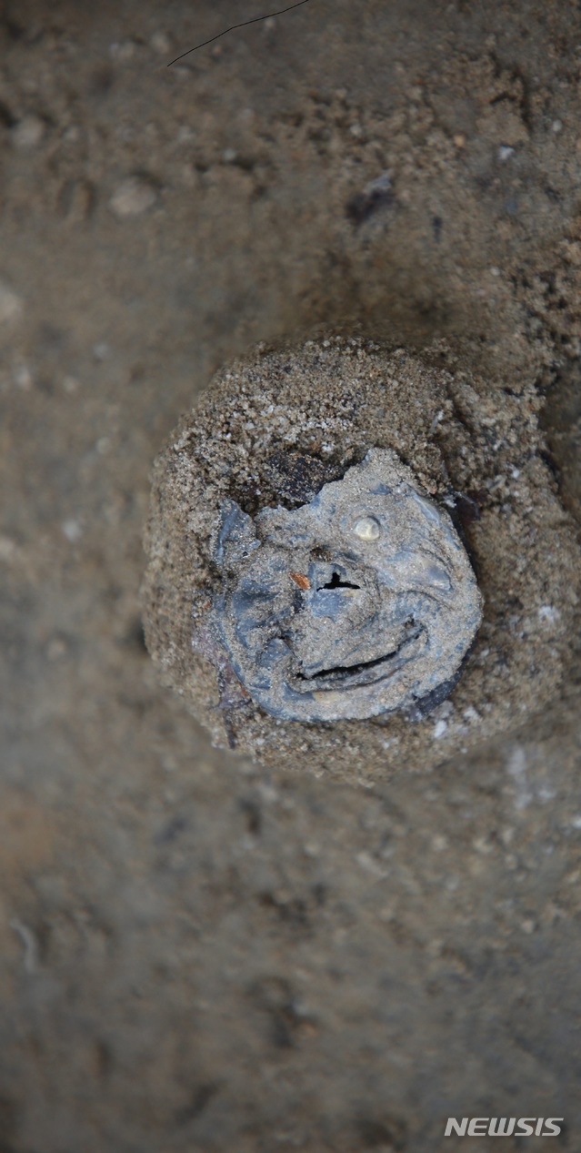 몽골 헨티 아이막의 도르릭 나르스 유적 제 160-E3호(배장묘)에서 출토된 사람얼굴모양 허리띠 장식  (사진 제공: 국립중앙박물관) 