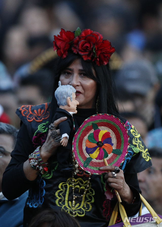 【멕시코시티=AP/뉴시스】15일 (현지시간) 멕시코 수도 멕시코시티의 소칼로 광장에서 멕시코 독립기념일을 앞두고 축하 모임이 열려 한 여성이 안드레스 마누엘 로페스 오브라도르 대통령 인형에 입 맞추고 있다.  .