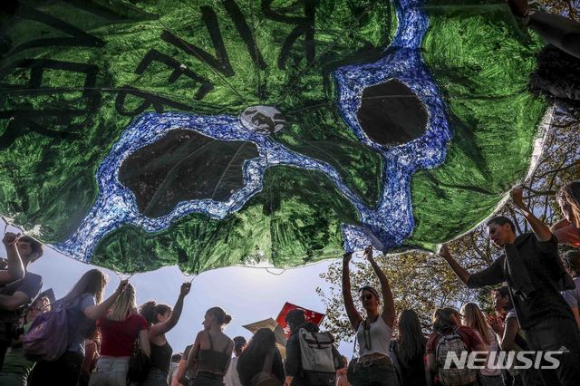 [ 뉴욕=AP/뉴시스] 지난 해 9월 20일 뉴욕의 기후변화 대행진에 참여한 환경운동가 청년들이 지구의 강을 보호하자는 초대형 깃발을 펼치며 시위를 벌이고 있다. 환경단체들은 코로나19 확산으로 올해 4월 22일 '지구의날 '50주년 행사는 온라인생중계로 진행하기로 했다고 발표했다.  