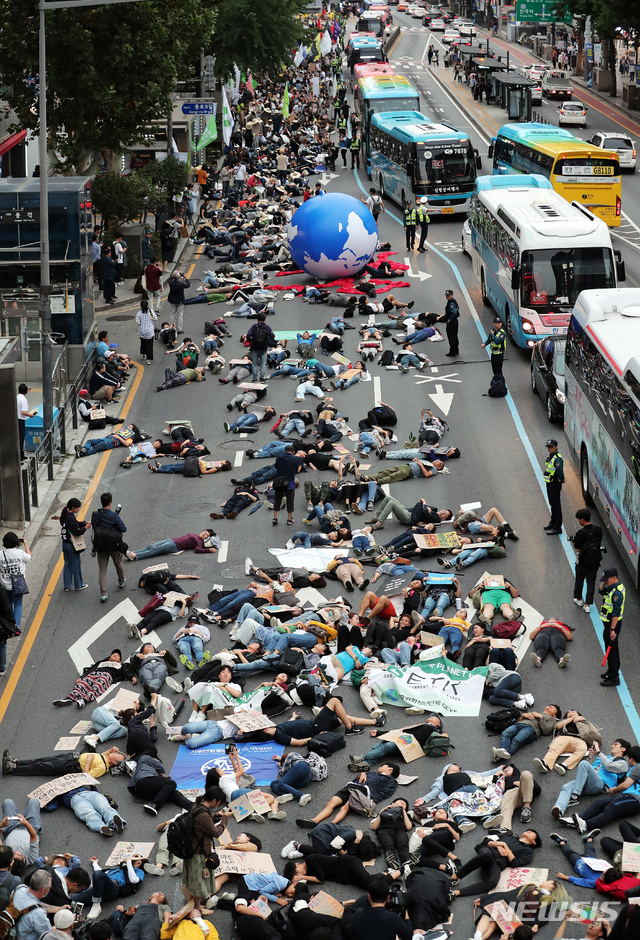 【서울=뉴시스】김병문 기자 = 국제 기후 파업 주간인 21일 오후 서울 종로 1가 사거리에서 열린 9·21 기후위기 비상행동 참가자들이 '기후 위기가 다가오면 생존의 위협이 다가온다'는 내용의 퍼포먼스를 하고 있다. 2019.09.21.  photo@newsis.com