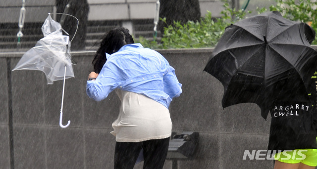 【부산=뉴시스】 하경민 기자 = 제17호 태풍 '타파'(TAPAH)가 북상 중인 22일 부산지역에 태풍경보가 발령된 기운데 해운대구 벡스코 인근에서 한 시민이 거센 바람에 우산을 놓치는 바람에 날아가고 있다. 2019.09.22.  yulnetphoto@newsis.com