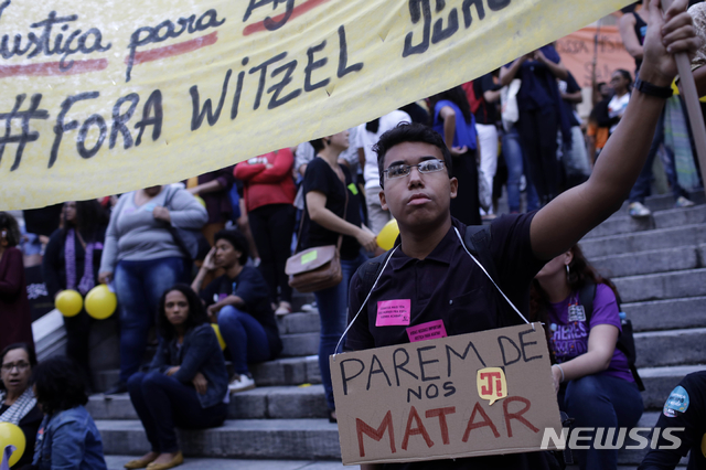 【리우데자네이루=AP/뉴시스】지난 20일(현지시간) 브라질 리우데자네이루 빈민가에서 경찰이 쏜 총에 8세 소녀 아가사가 숨진 것과 관련 23일 주민들이 "우리를 죽이지 말라"라고 쓰인 펼침막을 들고 항의 시위를 하고 있다.  아가사는 당시 어머니와 함께 밴 차량에 타고 있다가 경찰이 용의자를 향해 쏜 총알이 빗나가 이에 맞아 병원으로 옮겨졌으나 숨졌다. 2019.09.24.