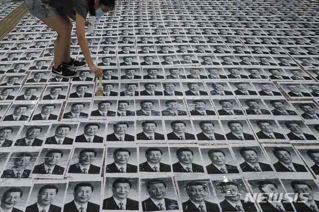 【홍콩=AP/뉴시스】1일(현지시간) 홍콩의 '레넌의 벽'(Lennon Wall)에 한 시위대원이 시진핑 중국 국가주석의 사진을 사람들이 밟고 지나가도록 바닥에 붙이고 있다. 홍콩 시위대는 중국의 70주년 국경절인 1일 경찰의 불허 방침에도 대규모 시위를 벌일 것을 예고한 바 있다.시위대는 중국은 국경절을 축하하지만 홍콩은 톈안먼 사건 등으로 수많은 사람이 목숨을 잃었다면서 이를 ‘추모’할 것이라고 밝혔다. 2019.10.01.