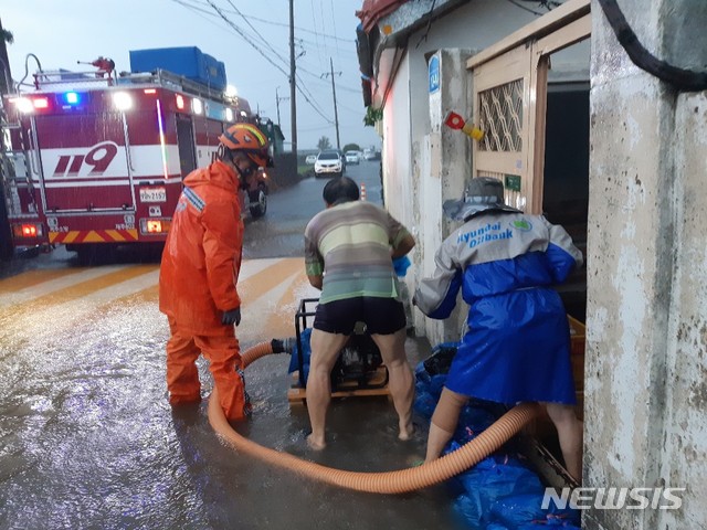 【제주=뉴시스】배상철 기자 = 강한 비를 동반한 제18호 태풍 ‘미탁’(MITAG)이 북상하면서 제주시 내도동 한 주택이 침수해 소방대원이 배수를 돕고 있다. 2019.10.02. (사진=제주소방본부 제공)bsc@newsis.com