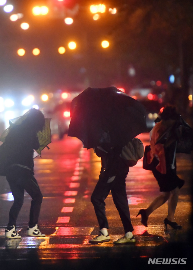 【부산=뉴시스】 하경민 기자 = 제18호 태풍 '미탁'(MITAG)이 북상하면서 부산지역에 '태풍경보'가 발효된 2일 오후 부산 해운대구의 한 횡단보도에서 시민들이 비바람에 맞서 힘겹게 걸어가고 있다. 2019.10.02.  yulnetphoto@newsis.com