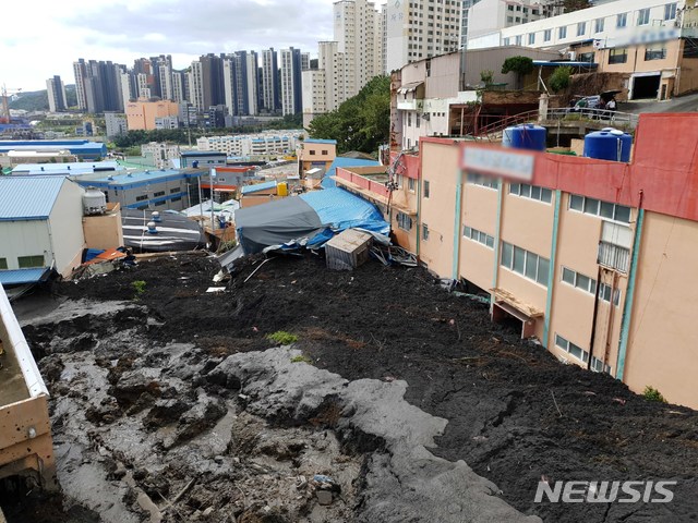 【부산=뉴시스】 3일 오전 9시 5분께 부산 사하구 구평동의 한 야산에서 산사태가 발생, 토사가 쏟아지면서 인근 샌드위치패널 구조의 공장과 주택 1채, 천막으로 된 식당 가건물 1개동 등을 덮쳤다.  이로 인해 주택에 3명, 식당에 1명 등 총 4명이 매몰된 것으로 추정되고 있다. 2019.10.03. (사진=부산소방재난본부 제공)  photo@newsis.com  