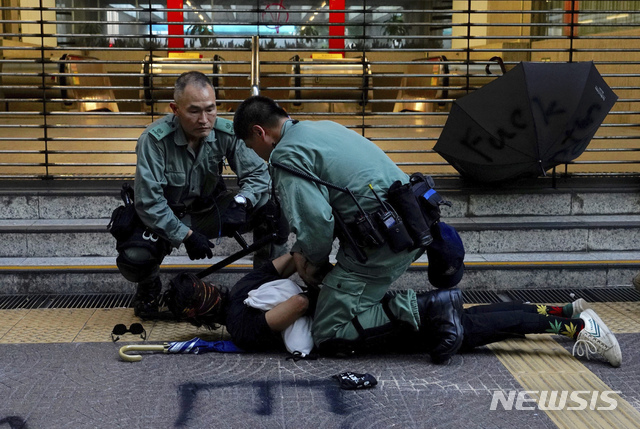 【홍콩=AP/뉴시스】'복면금지법' 시행 첫날인 5일(현지시간) 홍콩 거리에서 시위 중이던 한 시위 남성이 경찰에 제지당하고 있다.  '복면금지법'에 반대하는 시위가 격화되면서 지하철과 열차 운행이 전면 중단됐다. 2019.10.05. 