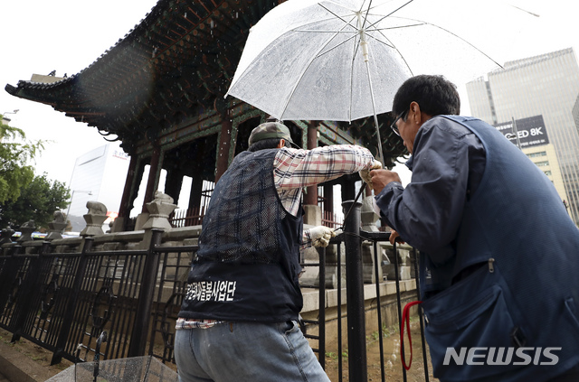 【서울=뉴시스】최진석 기자 = 7일 오전 서울 종로구 사적 171호 고종 어극 40년 칭경 기념비에서 종로구문화재돌봄사업단 관계자들이 훼손된 펜스 복구작업을 하고 있다. 박원순 서울시장은 이날 오전 YTN라디오 '노영희의 출발 새아침' 인터뷰에서 "3일 광화문 집회 과정에서 참가자들이 사적인 고종 어극 40년 칭경 기념비 내부로 들어와서 음식물, 주류를 섭취했다"며 "거기는 출입금지 구역이고, 또 현장에서 직원들이 출입을 막고 2시간 내내 경보음을 내보냈는데도 불구하고 펜스라든지 시설물 일부를 훼손했다"고 밝혔다. 2019.10.07.myjs@newsis.com