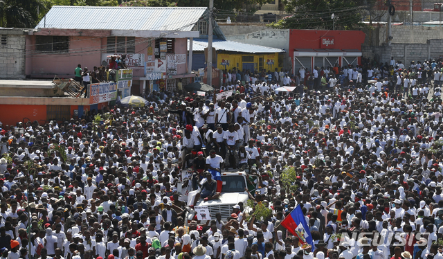 【포르토프랭스=AP/뉴시스】 지난 달 13일 아이티 수도 포르토프랭스에서 예술계가 주도하는 조베넬 모이즈 아이티 대통령 퇴진 요구 시위가 열려 모인 시위대가 행진하고 있다.  대통령 퇴진을 요구하는 이번 시위는 근 한 달 동안 상점과 학교가 문을 닫는 등 전국을 마비시키고 있다. 2019.10.14.