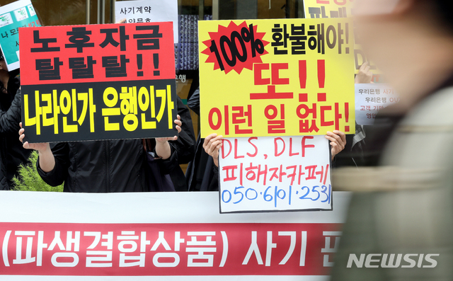 【서울=뉴시스】김병문 기자 = DLF/DLS피해자대책위원회 관계자들이 16일 오후 서울 중구 KEB하나은행 본점 앞에서 열린 우리은행·KEB하나은행 DLF(파생결합상품) 사기판매 규탄 집회에 참석해 손피켓을 들고 있다. 2019.10.16.  dadazon@newsis.com