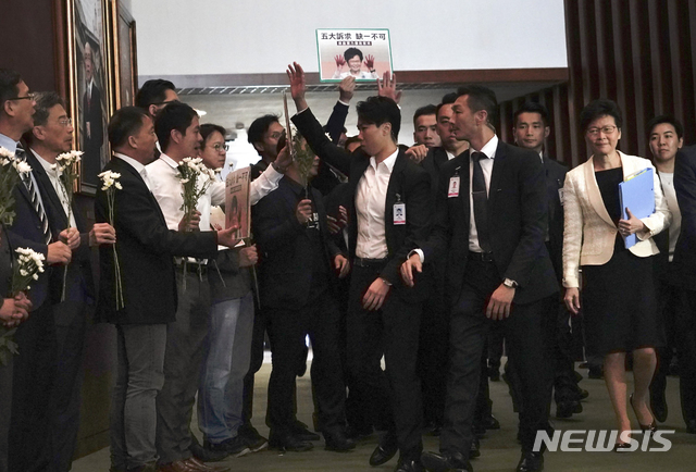 【홍콩=AP/뉴시스】17일 캐리 람 홍콩 행정장관이 입법회 건물을 떠나려 하는 가운데 야당 의원들이 조화와 피켓을 들고 항의하고 있다. 2019.10.17