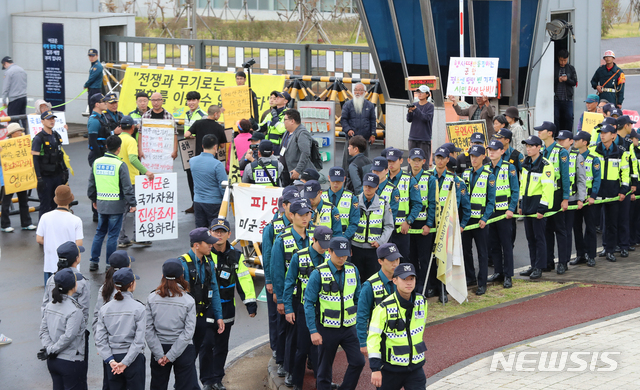 [서귀포=뉴시스]우장호 기자 = 강정마을 해군기지 반대주민회 관계자들이 18일 오전 제주 서귀포시 제주해군기지 정문 앞에서 유엔군사령부(유엔사)의 기지 방문 경위 해명을 촉구하는 기자회견을 진행 중인 가운데 경찰과 대치하고 있다. 사진은 이 사건과 관련이 없음. 2019.10.18. woo1223@newsis.com