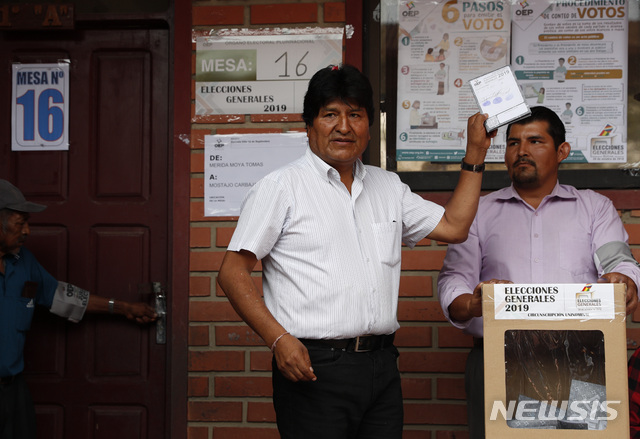 20일 남미 볼리비아 대선에서 4선 연임을 노리는 에보 모랄레스 대통령이 투표 직전 표를 들고 포즈를 취하고 있다   AP