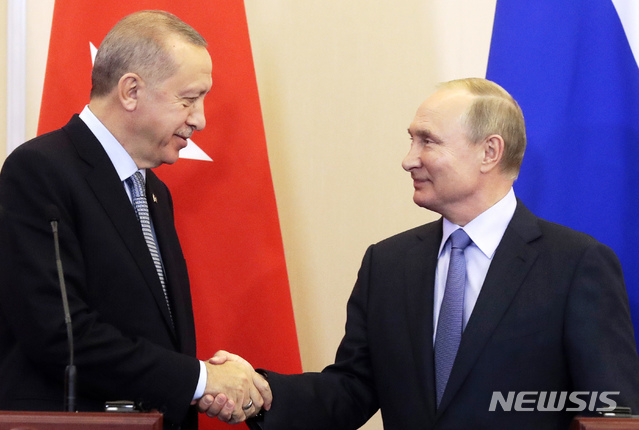 【소치=AP/뉴시스】블라디미르 푸틴 러시아 대통령(오른쪽)과 레제프 타이이프 에르도안 터키 대통령이 22일(현지시간) 러시아 소치에서 정상회담을 가진 뒤 공동기자회견을 하며 악수를 나누고 있다. 2019.10.23.