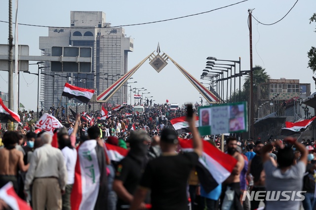 25일 이라크 수도에서 반정부 시위대가 엄중한 경호가 펼쳐지는 관청단지로 가기 위해 다리를 건너고 있다  AP