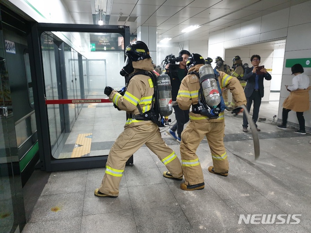 【서울=뉴시스】정성원 수습기자 = 29일 오후 3시께 서울 구로구 2호선 신도림역 일대에서 진행된 재난대응 안전한국훈련에서 소방 관계자들이 열차 화재를 진압하고 있다. 2019.10.29