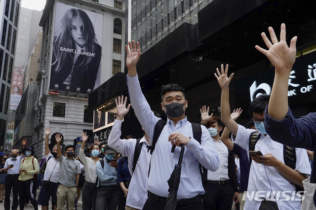 【 홍콩=AP/뉴시스】홍콩 금융가에서 12일 점심시간에 사무실 근로자들, 일명 '넥타이부대'가 시위대가 정부에 요구하는 5가지를 상징하는 다섯 손가락을 펼쳐보이며 동조 시위를 벌이고 있다. 2019.11.12 