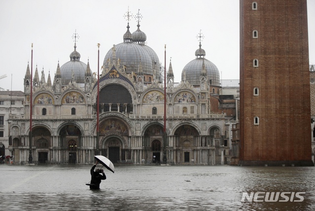 지난 12일(현시시간) 53년 만의 최악의 홍수 피해를 입은 베네치아에서 한 사진가가 물에 잠긴 산마르코 대성당을 찍고 있다. 베네치아 젊은이들은 16일 조수 수위가 낮아지면서 피해복구 자원봉사를 하고 있다. 2019.11.17