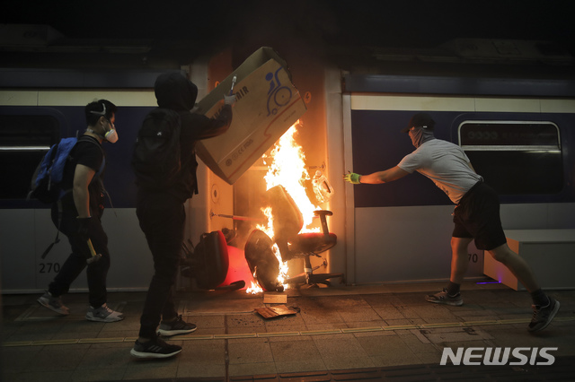 【홍콩=AP/뉴시스】13일(현지시간) 홍콩의 중문대학 MTR 역 내에서 시위 학생들이 열차에 불을 지르고 있다. 시위대는 도로에 불붙은 바리케이드를 설치하고 열차를 부수거나 불을 지르는 등 대중교통을 방해해 도시 기능 마비를 시도하면서 최루탄과 물대포 등을 쏘며 저지하는 경찰과 충돌하고 있다. 시위대를 폭도로 규정한 캐리 람 행정장관은 강경 진압 방침을 굽히지 않고 있다. 2019.11.13.